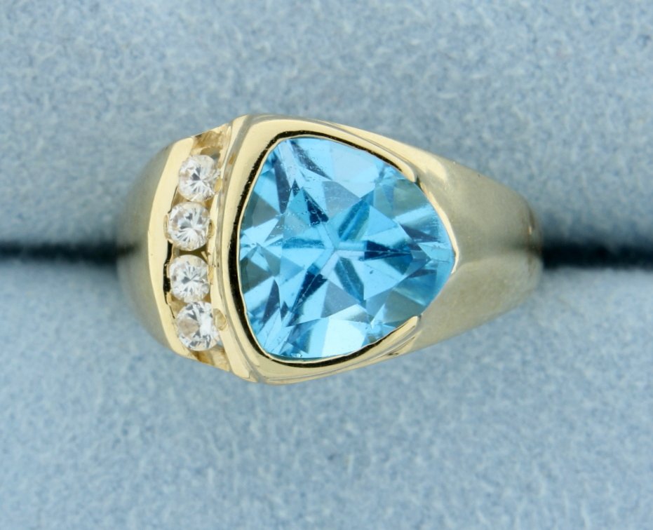 Blue Topaz & White Zircon ring: Lovely Blue Topaz and white zircon ring set in 14k yellow gold. The center Blue Topaz is trillion cut 10mm x 10mm! With 4 white zircon set in channel. Great look & style! Size 8 4.9g
