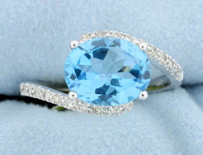 Genuine 2.40CT Blue Topaz & Diamond Ring set in 14K: The designers of this 14k white gold ring created a different look by setting this 2.40ct genuine Blue Topaz, oval cut, on its side. Accented by .18ctw diamonds, SI clarity, G/H color, this ring adds 