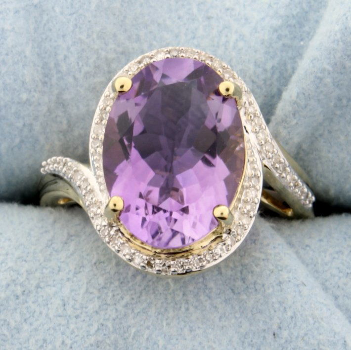 Amethyst and diamond ring: Gorgeous 14k yellow gold ring with stunning oval cut Amethyst set in halo style setting accented with 0.20 carats of diamonds. 5.6g Size 7