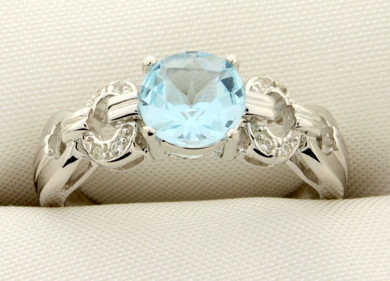 Cartier style ring with genuine Sky Blue gemstones: Stunning sterling silver Cartier style ring with gorgeous round genuine Sky Blue Topaz center gemstone that sparkles amongst the white sapphires set in circle design on the shank. Size 8 3.2g