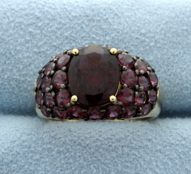 6 Carat Rhodolite Garnet 14k Ring: The center is a 3 carat gemstone with 30 round garnets set in needle point settings for a great fashion dome of color! The total weight of side garnets is 3 carats. Size 7. 4.8g