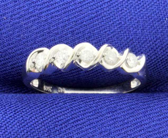 Diamond 10K White Gold Band: There are 5 brilliant cut diamonds in a line weighing 0.20ctw (1/5ctw) clarity I1 and color H-I. Prong set with a wave design separating them to create a unique look. The width is 4mm. Size 7. Very go