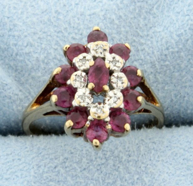 Ruby and Diamond Ring: 10k Yellow Gold. .08ct TW of diamonds. Center Ruby is Marquis 2.5x4.5 mm. Has ten 2.5mm round Rubies surrounding it as well. Size 5.25. 3.4g.