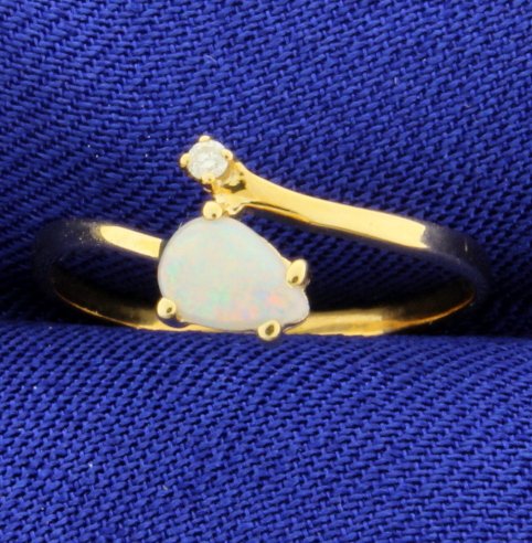 Opal & Diamond Bypass Ring: 14 K yellow gold. Opal is 5.5mm long, great color of play! .02 ct. diamonds. Size 5. 1.0g