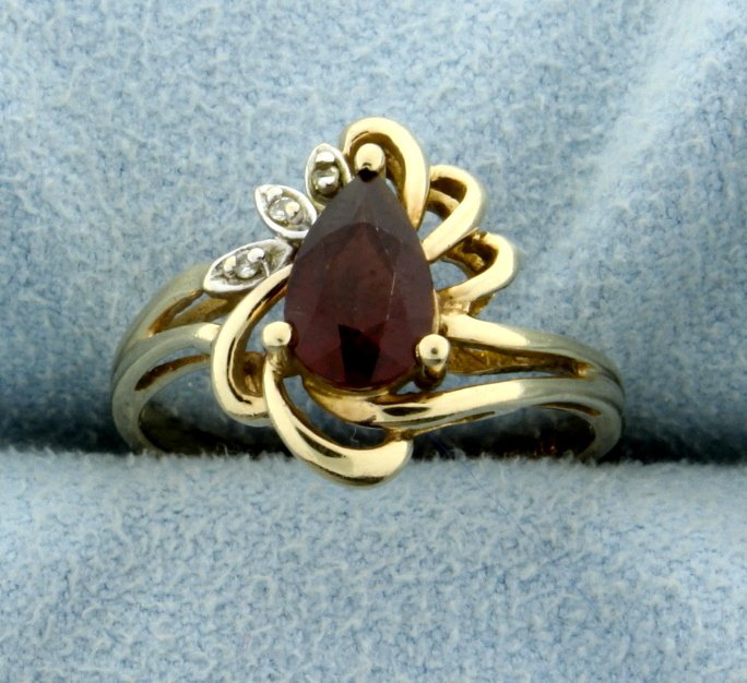 1ct Garnet and Diamond Ring: In 10K yellow gold, this ring contains 1ct pear shaped garnet gemstone, it also contains three 1/2pt diamonds. Size 6 1/4 2.4g