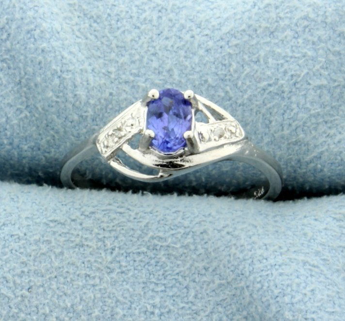 1/2 ct Tanzanite and Diamond Sterling Silver Ring: Contains 1/2 ct Genuine Tanzanite gemstone and two .01 ct Diamonds. Set in platinum over a sterling silver band. Size 7.5. 1.8g.