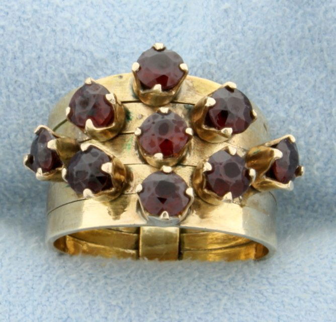 1.35ct Total Weight Garnet Stack Ring: In 14K yellow gold, this ring contains nine 3.5mm garnet gemstones. Individual bands are separated but are clipped together in back of shank. Very unique ring! Size 5 1/2 6.3g