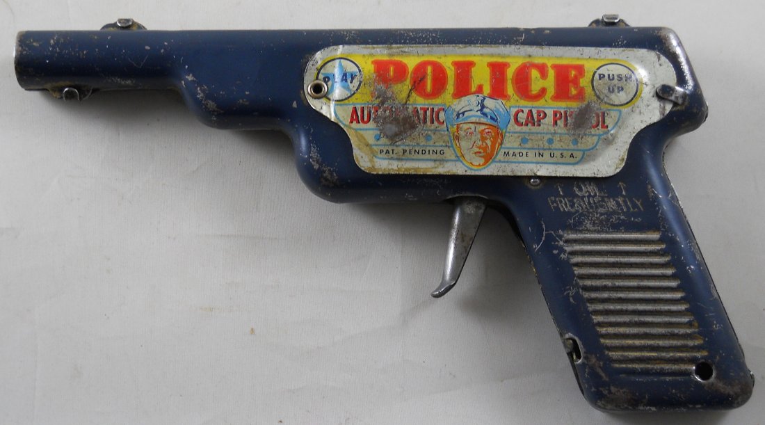 Vintage Combination Cap Gun & Clicker Gun: Police Automatic Cap Pistol. Unknown manufacturer. Overall playwear with a name inscribed on it. Appears to function properly. 7.75"L