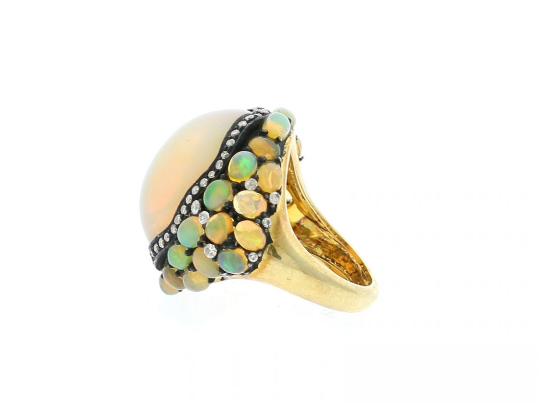 24.11 Ct Opal And Diamond Dome Ring: A smooth 24 CT Opal is surrounded by opal cabochons and diamonds set in 18kt Gold.