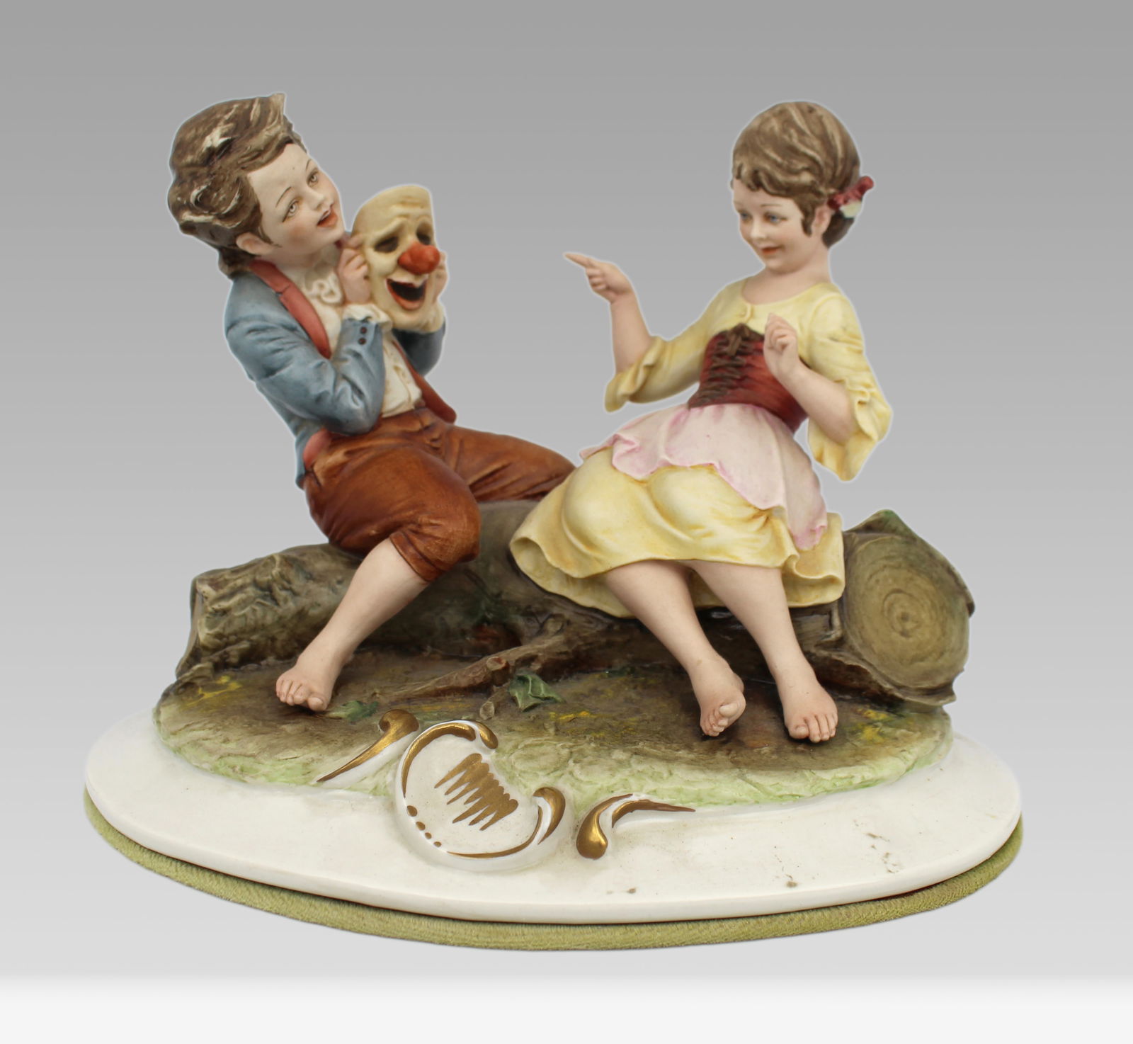 Capodimonte Figurine Girl & Boy With Clown Mask By Merli: Title: Capodimonte Figurine Girl & Boy with Clown Mask by Merli Description: Measures 22.5 x 15 x 16 (height) cm. Pigtail to girl damaged Condition: