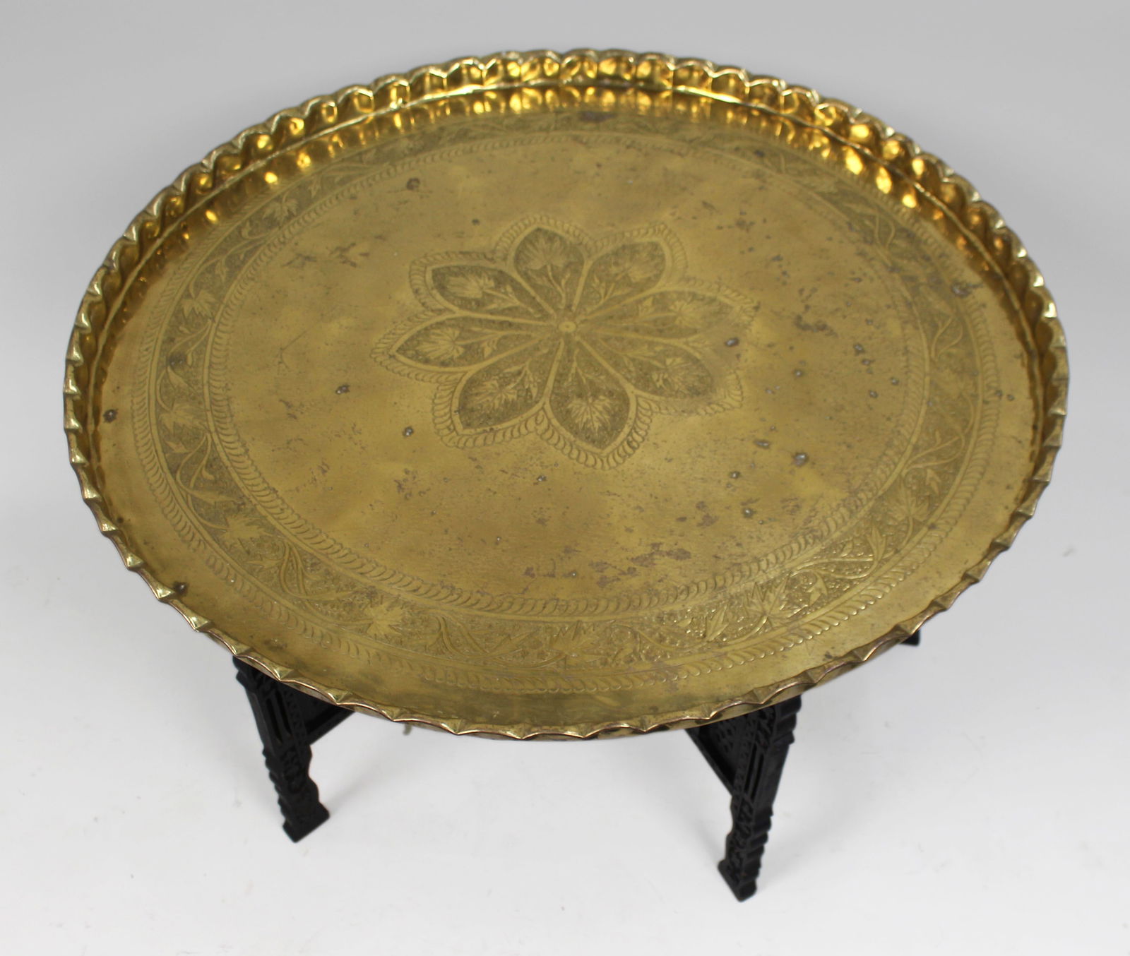Large Middle Eastern Brass Tray Table on Carved Hardwood Folding Stand: Title: Large Middle Eastern Brass Tray Table on Carved Hardwood Folding Stand Description: Large Mid 20th Century Middle Eastern Brass Tray Table Likely Morocc