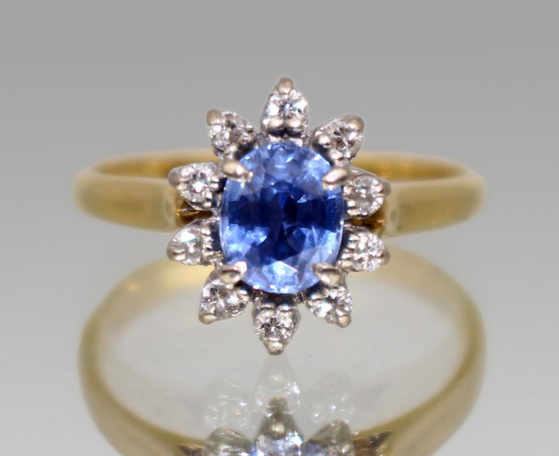 Vintage Cornflower Blue Sapphire & Diamond 18 ct. Cluster Ring: Title: Vintage Cornflower Blue Sapphire & Diamond 18 ct. Cluster Ring Description: Cornflower Blue Sapphire & Diamond Cluster Ring Central oval mixed cut blue sapphire measuring approx