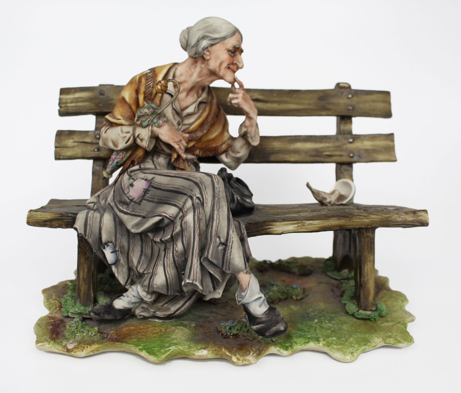 Capodimonte Lady Tramp on Bench: Title: Capodimonte Lady Tramp on Bench Description: Capodimonte Lady Tramp on Bench Made in Italy, c.1970. Finely modelled with lots of detail; richly hand painted. Measures 25 x 17 x 19