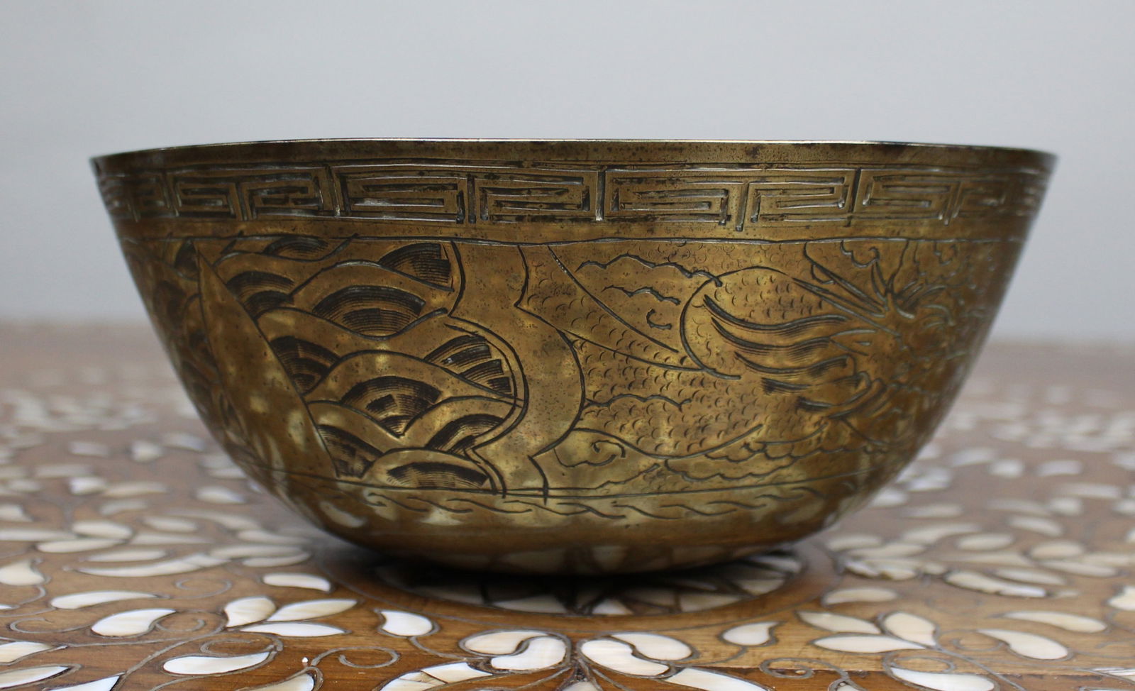Chinese Engraved Brass Bowl: Title: Chinese Engraved Brass Bowl Description: Chinese Engraved Brass Bowl Decorative Chinese brass bowl with engraved dragon and wave motifs and key-fret border to the rim. Stamped mark and
