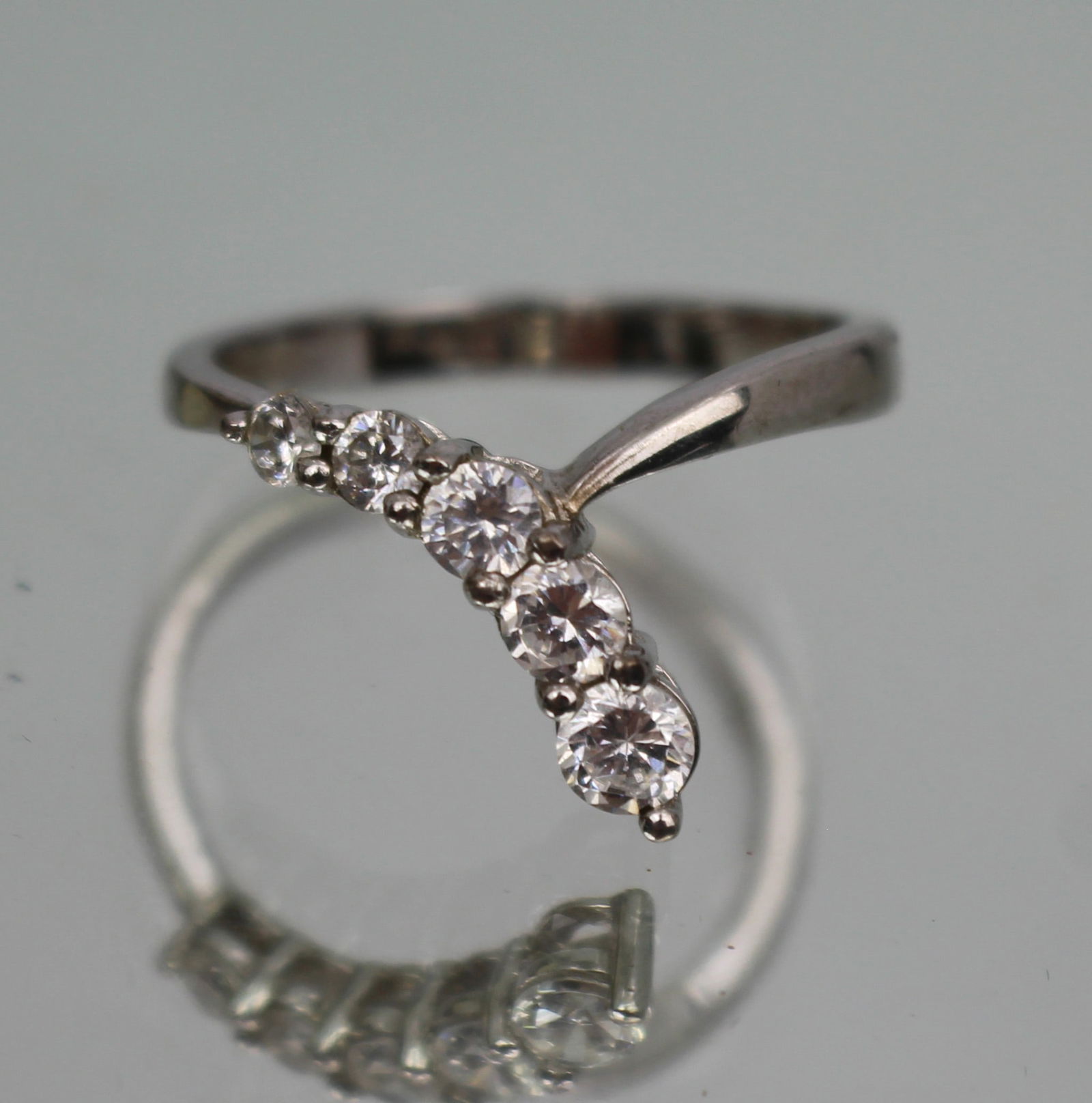 Vintage Silver Graduated CZ Ring: Title: Vintage Silver Graduated CZ Ring Description: Vintage Silver Graduated CZ Ring Stamped 925 Set with 5 graduated CZ stones Weight 3.1 g. Ring size T 1/2 Good
