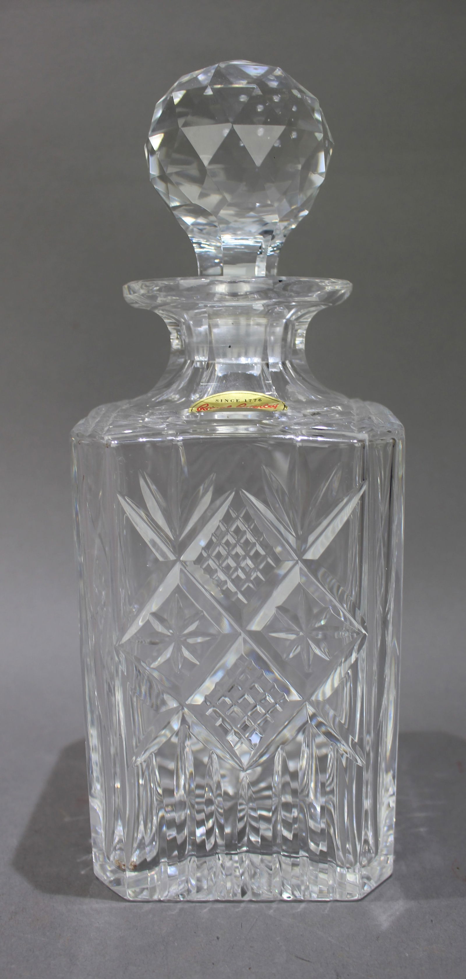 Vintage Royal Brierley Crystal Square Shaped Spirit Decanter: Title: Vintage Royal Brierley Crystal Square Shaped Spirit Decanter Description: Vintage Cheviot British Crystal Square Shaped Spirit Decanter. Factory label to decanter. Measures 10 x 10 x 26.5
