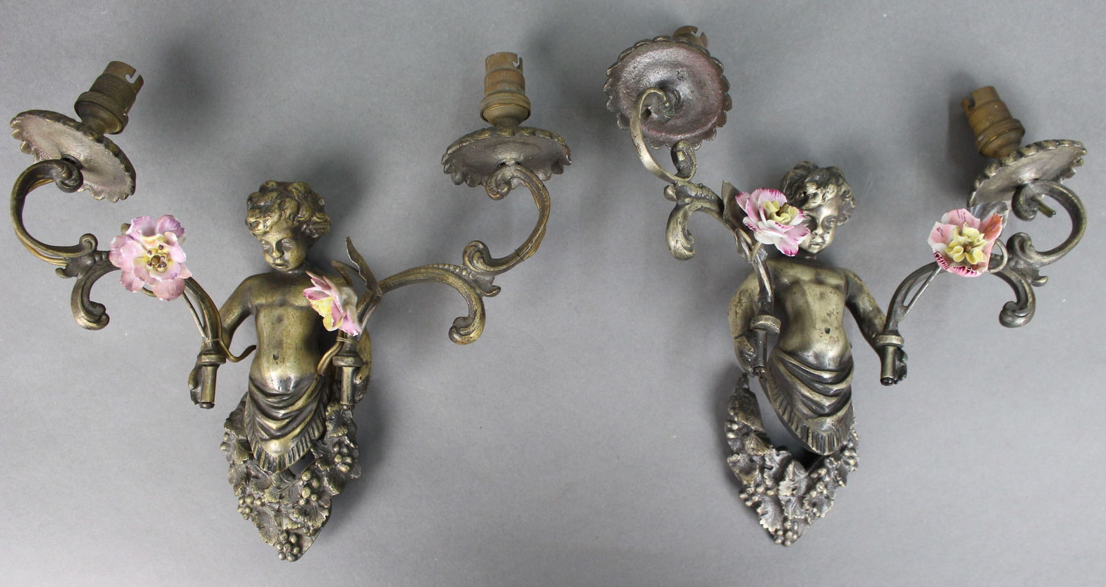 Pair of Antique French Style Cherub Wall Sconces with Porcelain Flowers: Title: Pair of Antique French Style Cherub Wall Sconces with Porcelain Flowers Description: Pair of Antique French Style Cherub Wall Sconces with Porcelain Flowers A decorative pair of antique
