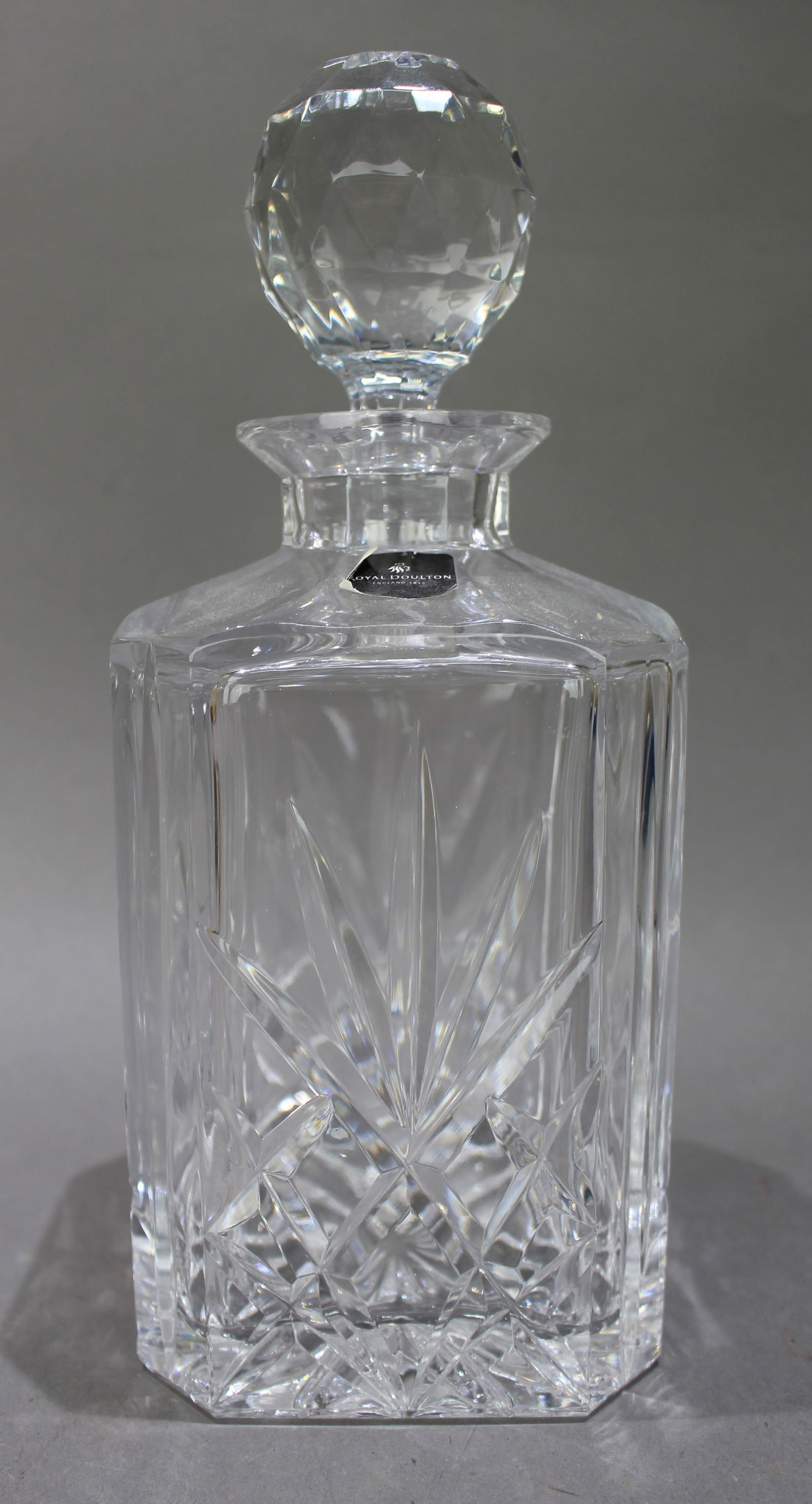 Vintage Royal Doulton Crystal Square Shaped Spirit Decanter: Title: Vintage Royal Doulton Crystal Square Shaped Spirit Decanter Description: Vintage Royal Doulton Crystal Square Shaped Spirit Decanter. Factory label to decanter. Measures 10 x 10 x 25