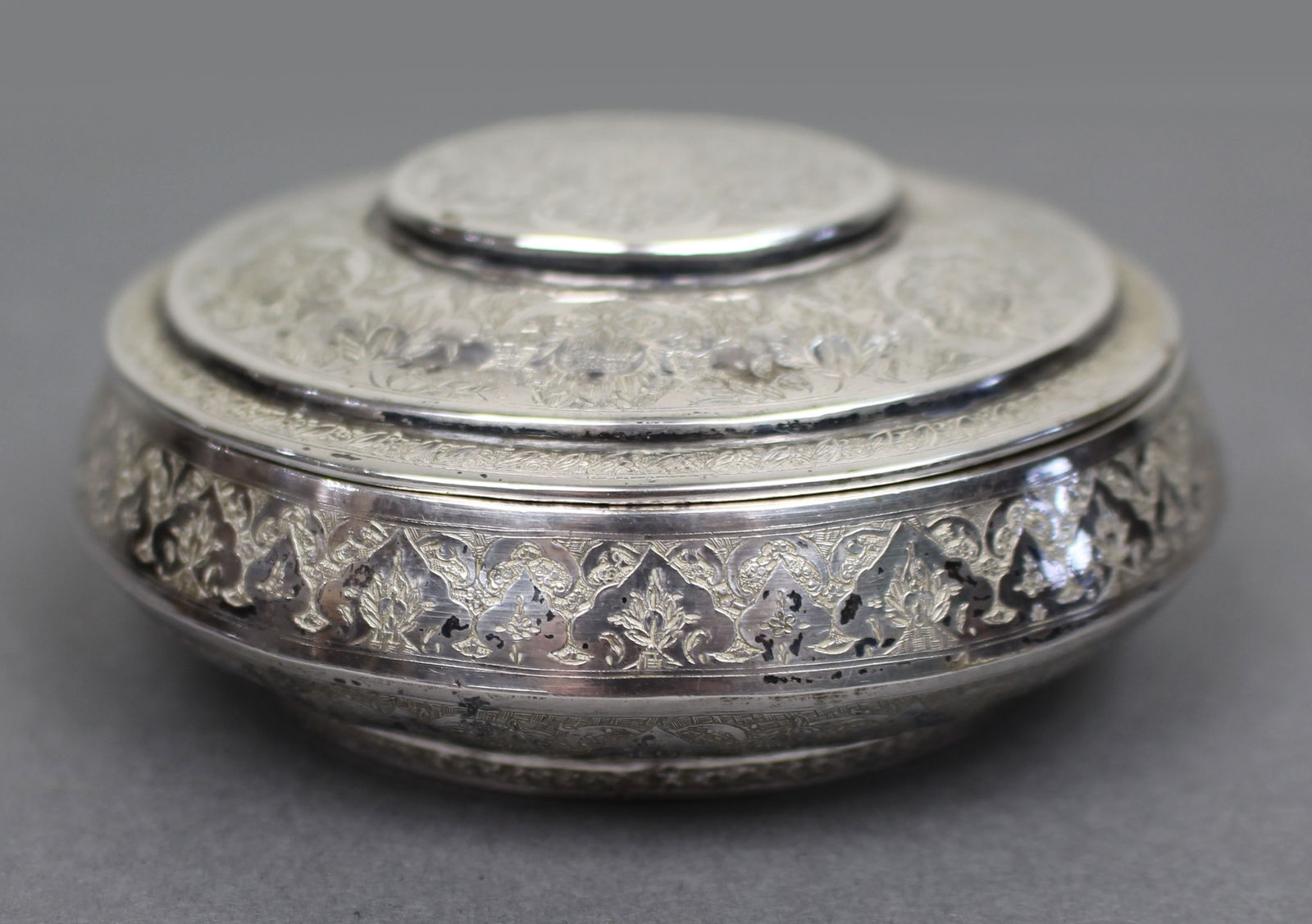Persian Silver Circular Box with Floral Motifs, Iran, c.1950: Title: Persian Silver Circular Box with Floral Motifs, Iran, c.1950 Description: Finely Engraved Persian Silver Circular Box A finely worked Persian silver circular box and cover, richly