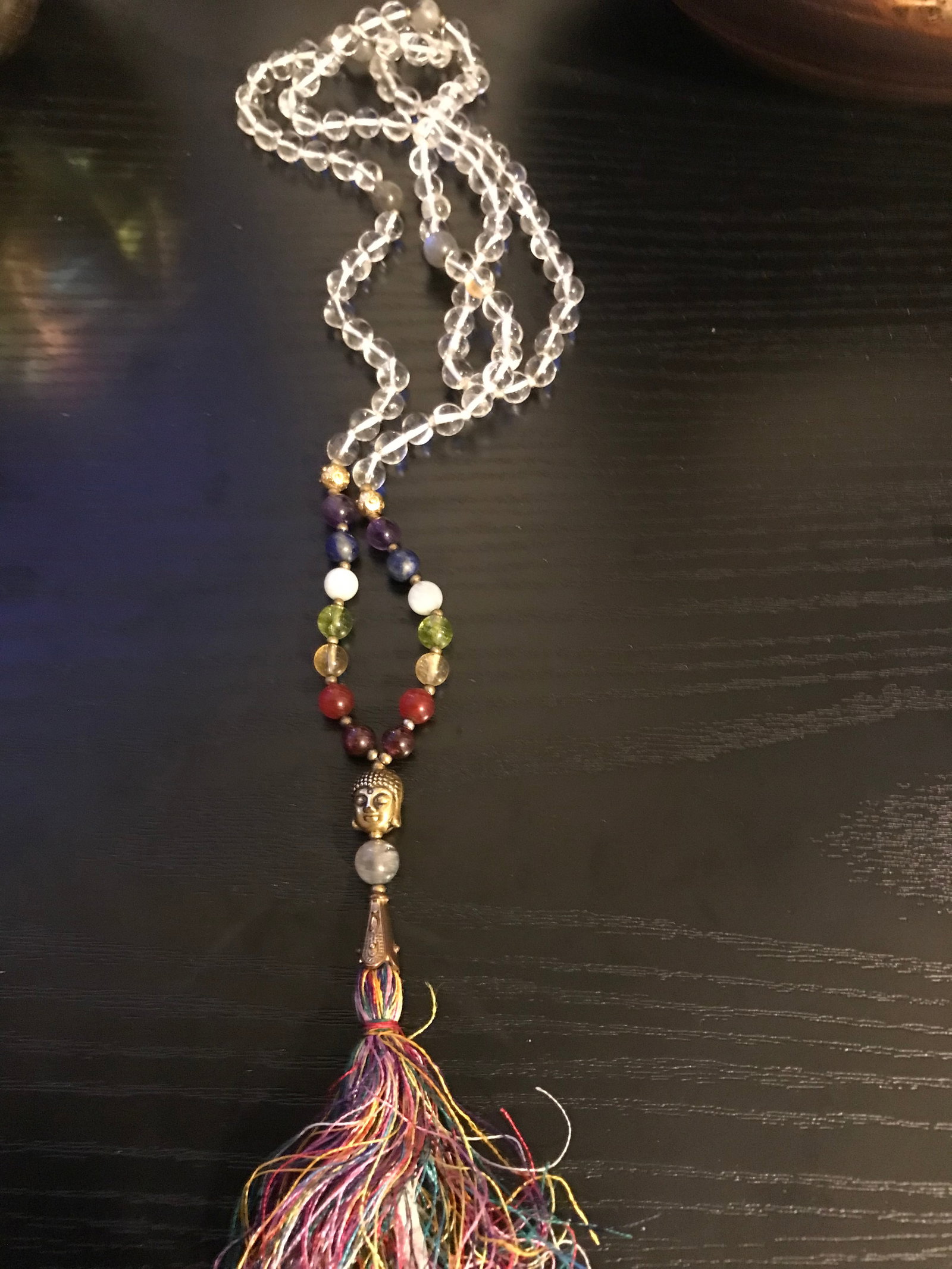 Clear Quartz Long Bead Necklace With Buddha Charm and Tassle: Title: Clear Quartz Long Bead Necklace With Buddha Charm and Tassle Description: Clear quartz polished beads long Necklace/ Mala with semi-precious stones. Centered with a Buddha charm and