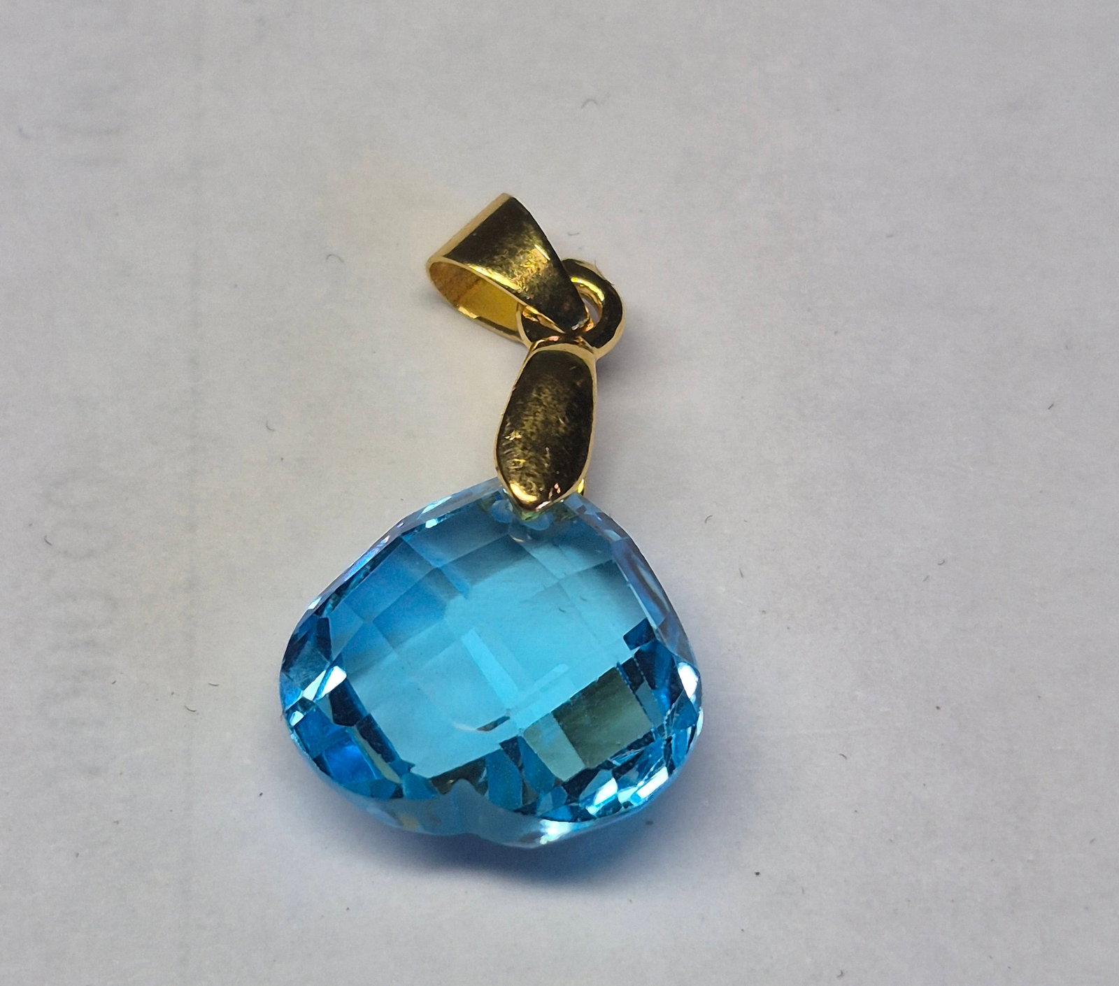 Natural Blue Topaz Heart Pendant – Faceted Gemstone Charm Gold Tone Bail: Title: Natural Blue Topaz Heart Pendant – Faceted Gemstone Charm Gold Tone Bail Description: Elegant pendant featuring a natural Blue Topaz gemstone in a romantic heart shape. The stone