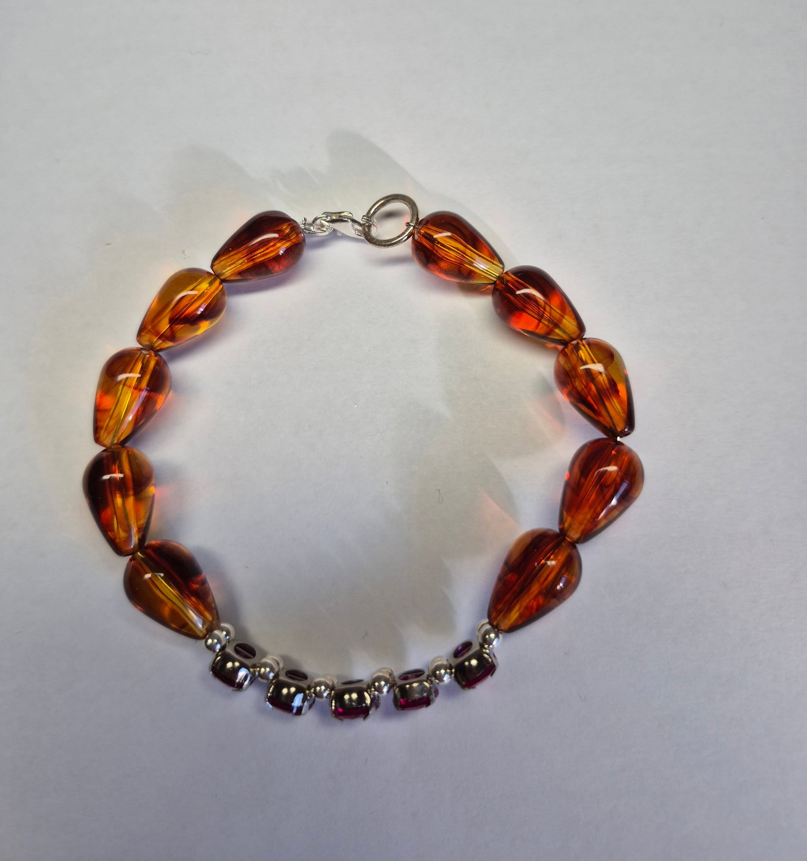 Natural Treated Ruby & Amber Bracelet in 925 Sterling Silver: Title: Natural Treated Ruby & Amber Bracelet in 925 Sterling Silver Description: Elegant handcrafted bracelet featuring rich honey-colored amber beads combined with five faceted treated ruby