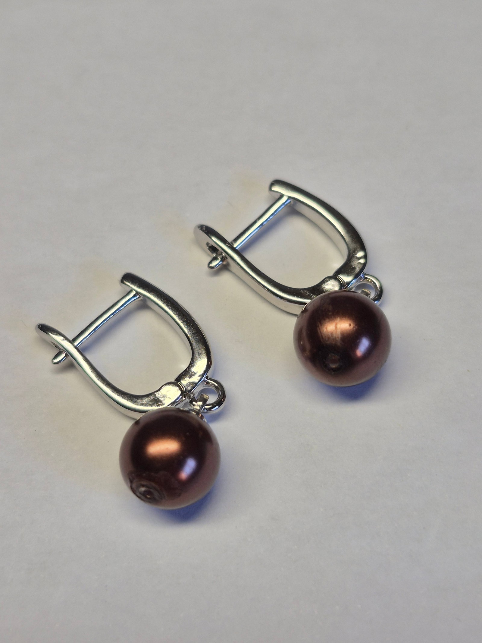 Silver Plated Earrings With Chocolate Pearl Beads – Elegant Drop Design: Title: Silver Plated Earrings With Chocolate Pearl Beads – Elegant Drop Design Description: A stylish pair of silver-plated drop earrings featuring lustrous chocolate-colored pearl beads. 