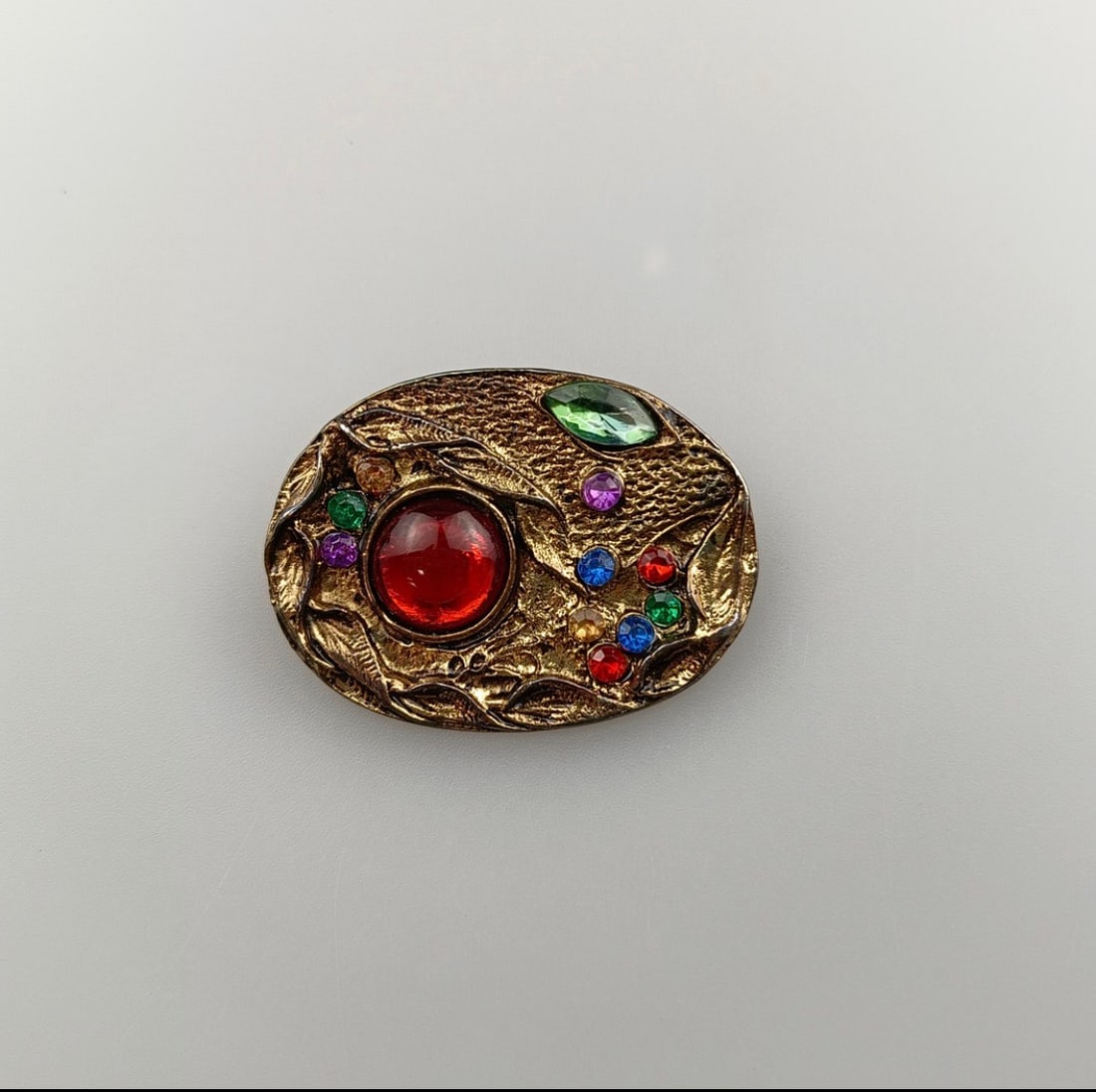 Vintage Renaissance Style Brooch With A Red Cabochon Centre: Title: Vintage Renaissance Style Brooch With A Red Cabochon Centre Description: A large, central red cabochon stone surrounded by smaller colourful stones. Often described as “