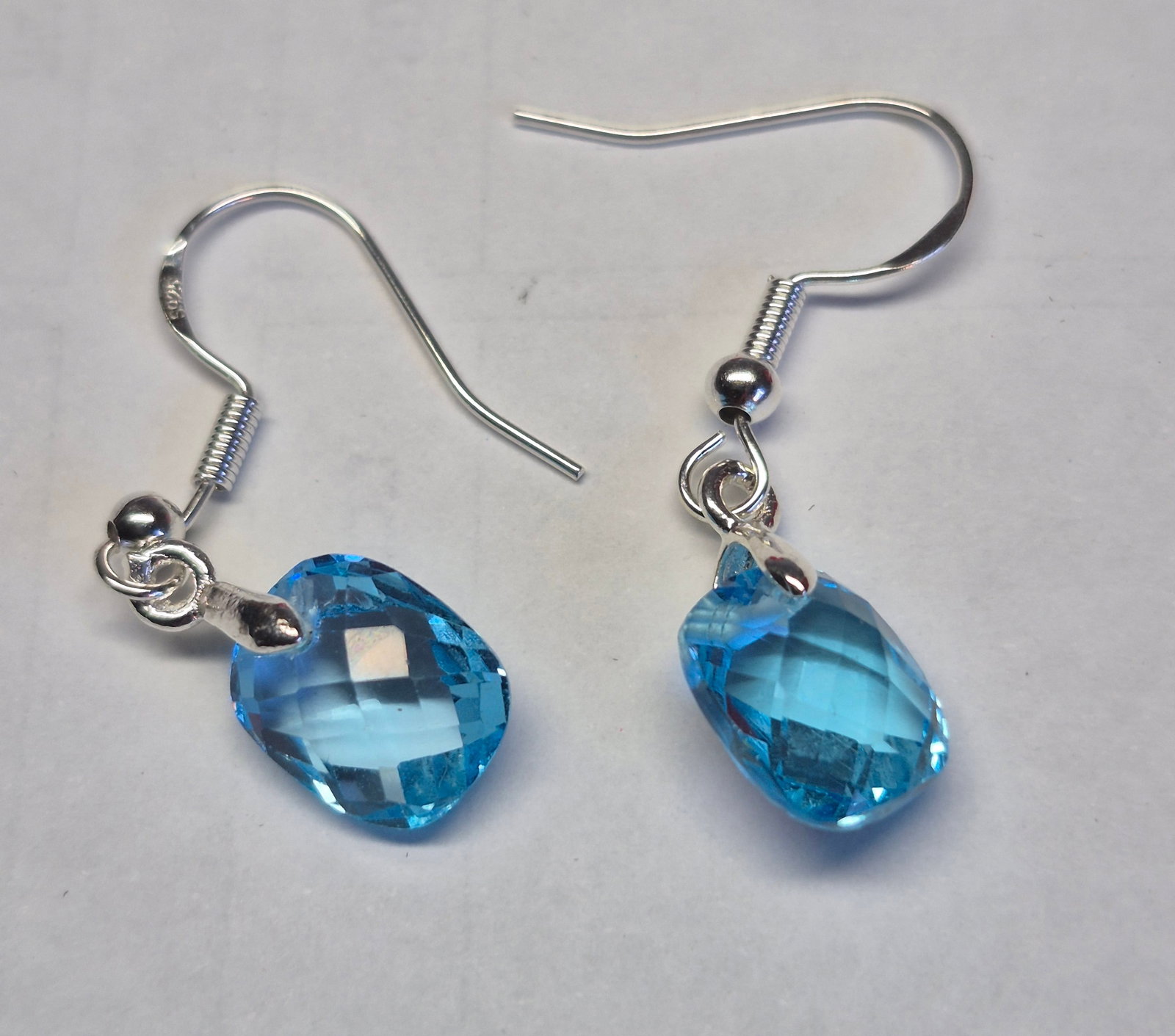 Natural Blue Topaz Drop Earrings in 925 Sterling Silver – Faceted Teardrop Gemstones: Title: Natural Blue Topaz Drop Earrings in 925 Sterling Silver – Faceted Teardrop Gemstones Description: Elegant and timeless earrings featuring natural Blue Topaz gemstones in a sparkling