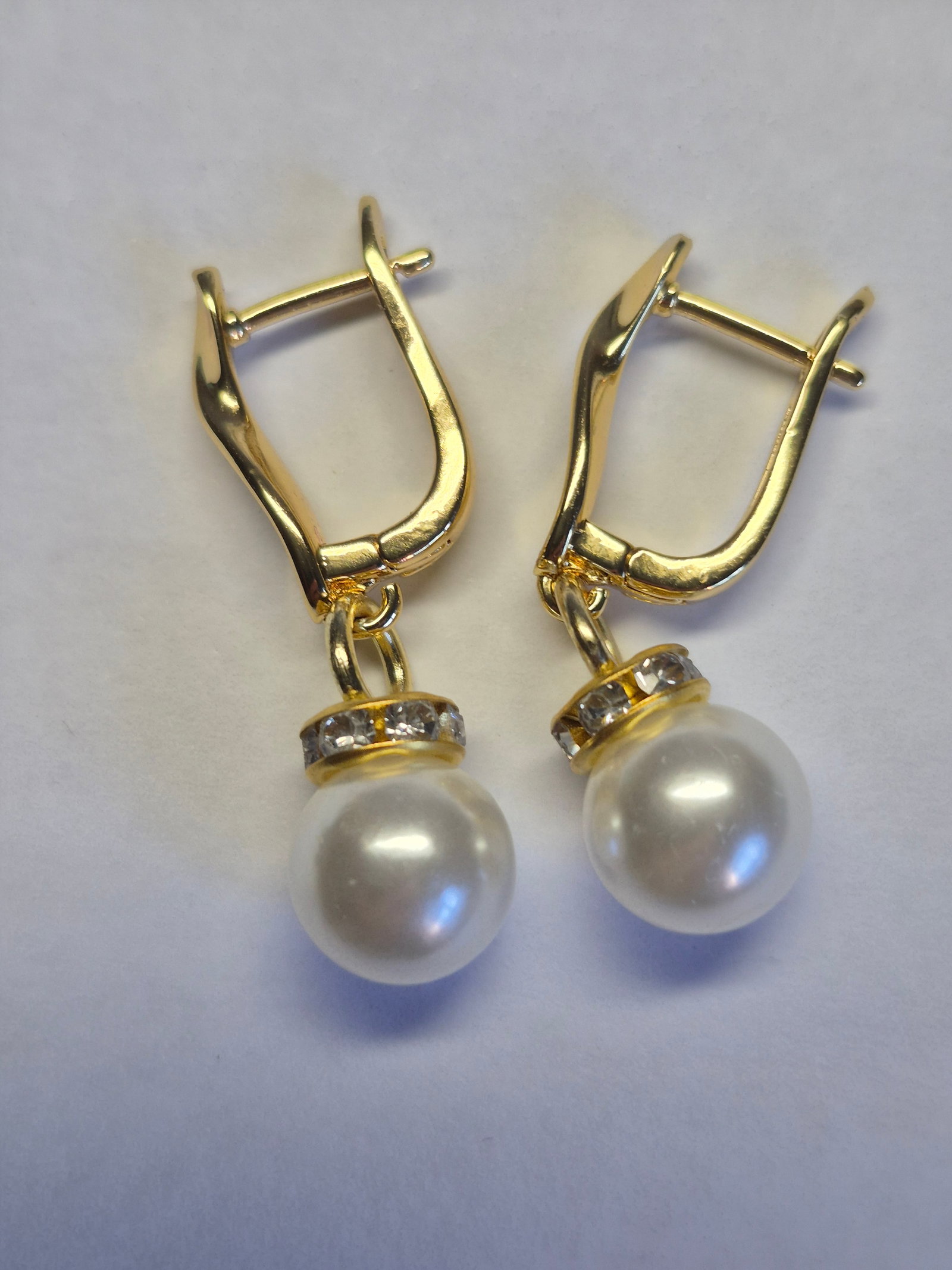 Gold Plated Pearl Drop Earrings With Crystal Accents: Title: Gold Plated Pearl Drop Earrings With Crystal Accents Description: Elegant pair of gold plated drop earrings featuring lustrous white pearl-style beads suspended beneath sparkling crystal