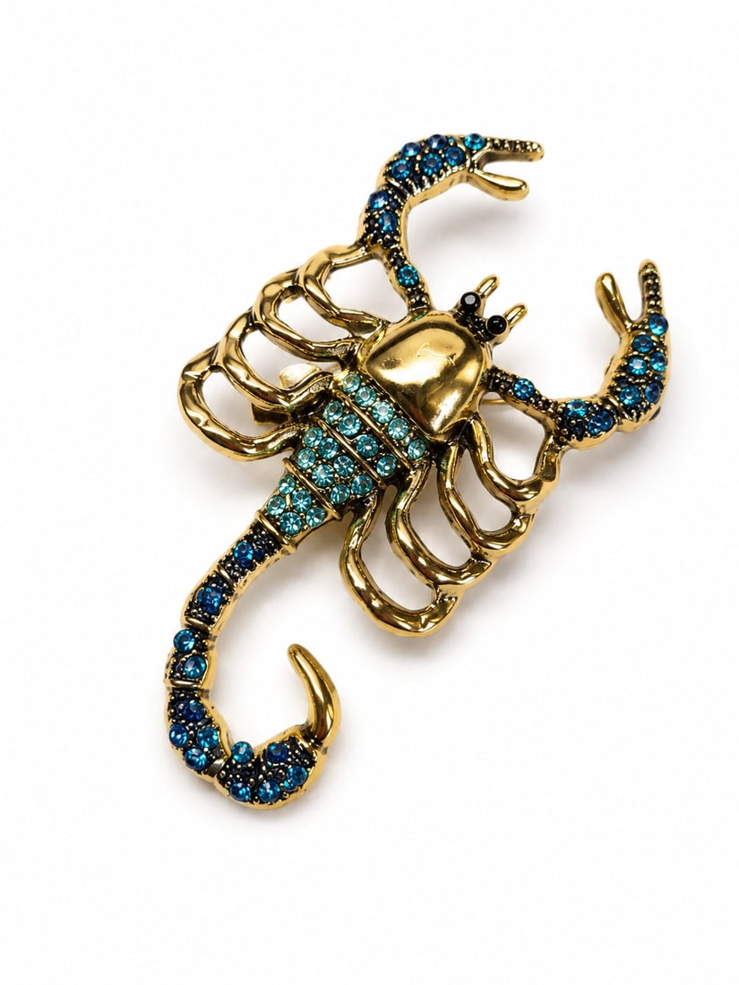 Vintage Blue Crystal Scorpion Brooch – Gold Tone Statement Pin: Title: Vintage Blue Crystal Scorpion Brooch – Gold Tone Statement Pin Description: Striking vintage-style scorpion brooch crafted in gold-tone metal and adorned with sparkling blue