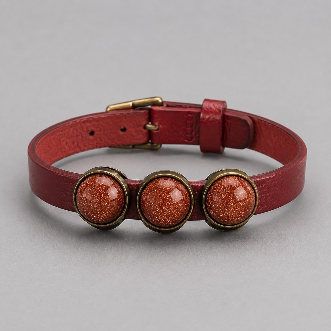 Red Leather Bracelet With Triple Goldstone Cabochons – Adjustable Vintage Style: Title: Red Leather Bracelet With Triple Goldstone Cabochons – Adjustable Vintage Style Description: Handcrafted red leather bracelet featuring three sparkling round Goldstone cabochons set in