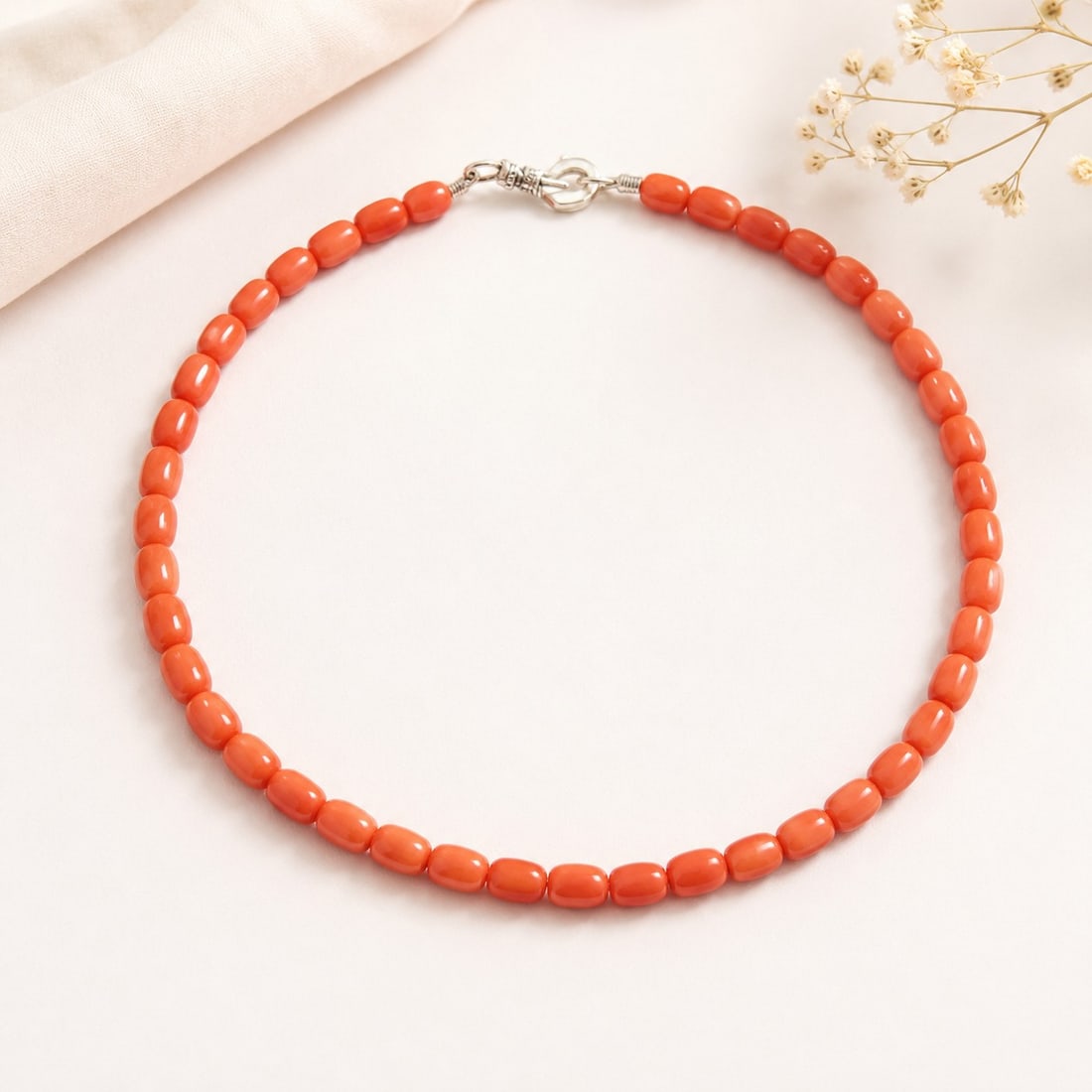 Coral Bead Necklace With Sterling Silver Clasp: Title: Coral Bead Necklace With Sterling Silver Clasp Description: Elegant necklace featuring smooth coral-colored beads in a warm salmon-orange hue, finished with a secure sterling silver