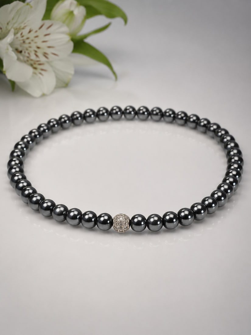Natural Hematite Bead Elastic Necklace With Crystal Accent: Title: Natural Hematite Bead Elastic Necklace With Crystal Accent Description: Elegant handmade elastic necklace featuring polished natural hematite beads and a sparkling crystal accent bead. 
