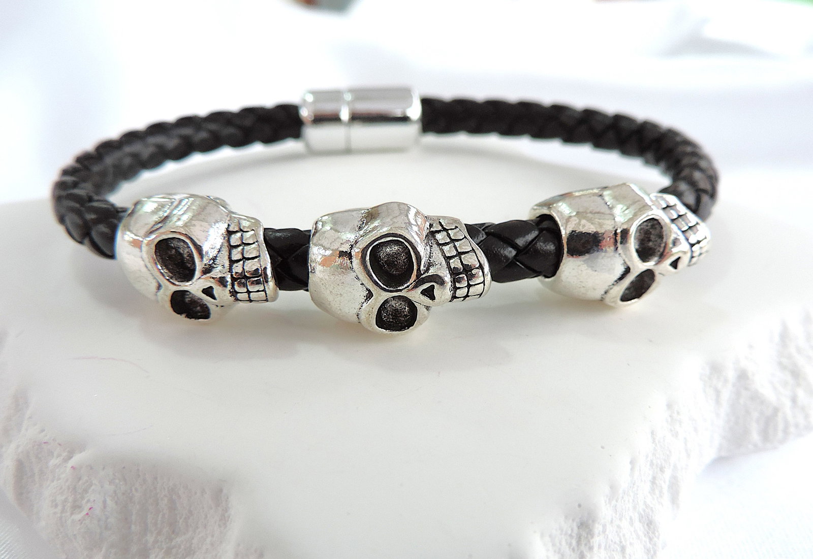 Men's Braided Leather Stainless Steel Skull Head Bracelet: Title: Men's Braided Leather Stainless Steel Skull Head Bracelet Description: Aethon designer braided black leather stainless steel triple skull head bracelet. Length 8.5 inches secured with a
