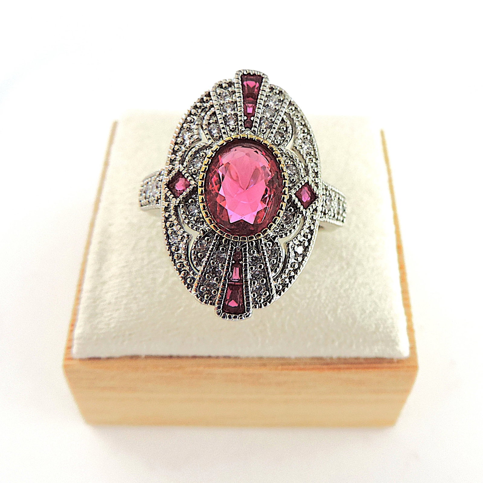Art Deco Style Red & White Gemstone Ring: Title: Art Deco Style Red & White Gemstone Ring Description: A stunning art deco style ring in silver tone metal set with an 8x6mm red gemstone surrounded by white gemstones. Ring siz