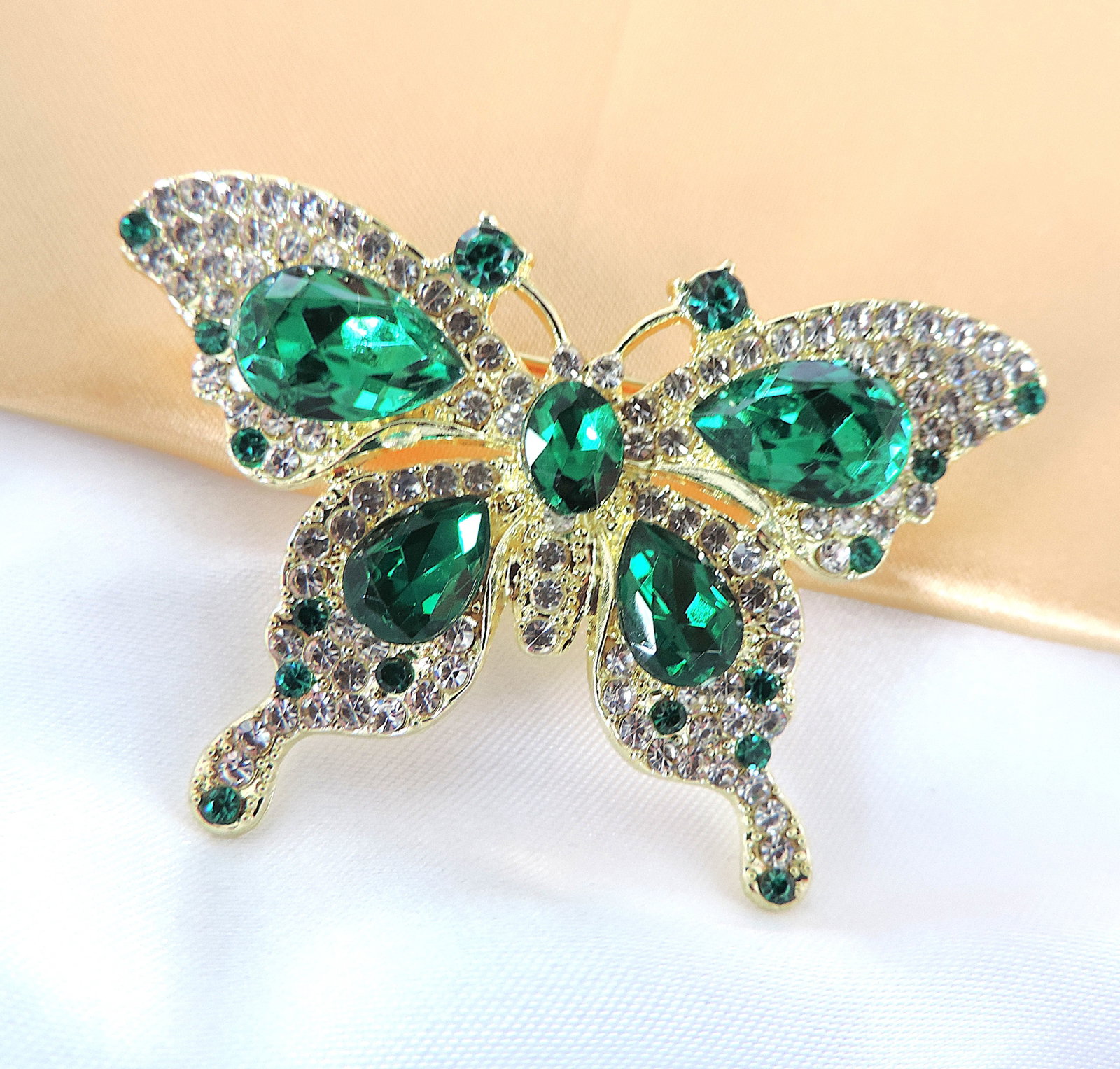 Green & WhIte Crystal Butterfly Brooch: Title: Green & WhIte Crystal Butterfly Brooch Description: A pretty gold tone brooch set with sparkling green & white crystals. Measurements: 6cmx3cm. Condition: New Delivery option: