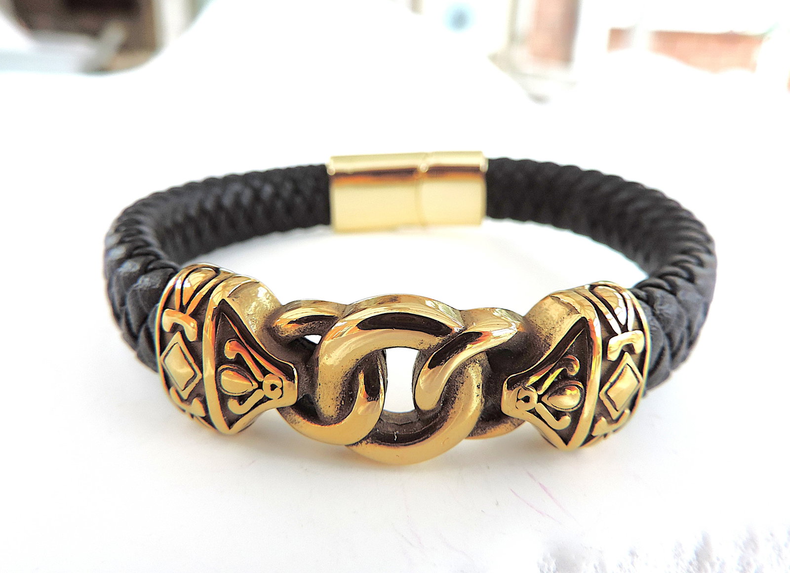 Aethon Black Leather Norse Bracelet: Title: Aethon Black Leather Norse Bracelet Description: Aethon black plaited leather & gold tone metal Norse bracelet. Measures 8.25 inches in length. (Part of liquidation stock of a