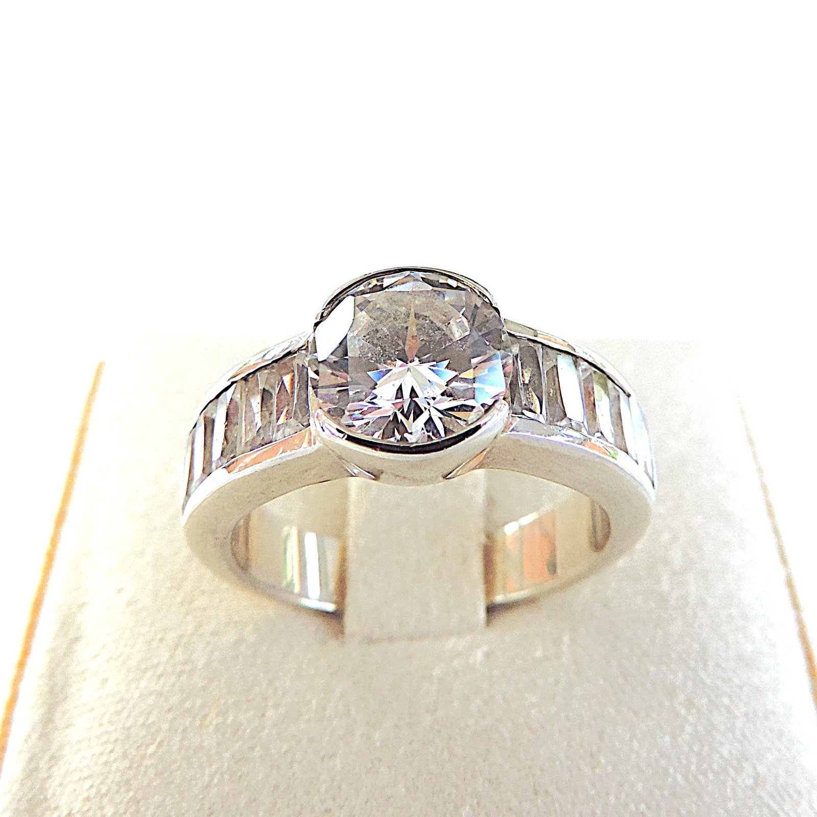 925 Silver 4.5 Carat Moissanite Gemstone Ring: Title: 925 Silver 4.5 Carat Moissanite Gemstone Ring Description: A stunning ring in 925 sterling silver set with an 8mm round (TCW 2.0) and 10 x 5x3mm (TCW 2.5) Emerald cut Moissanite gemstones.