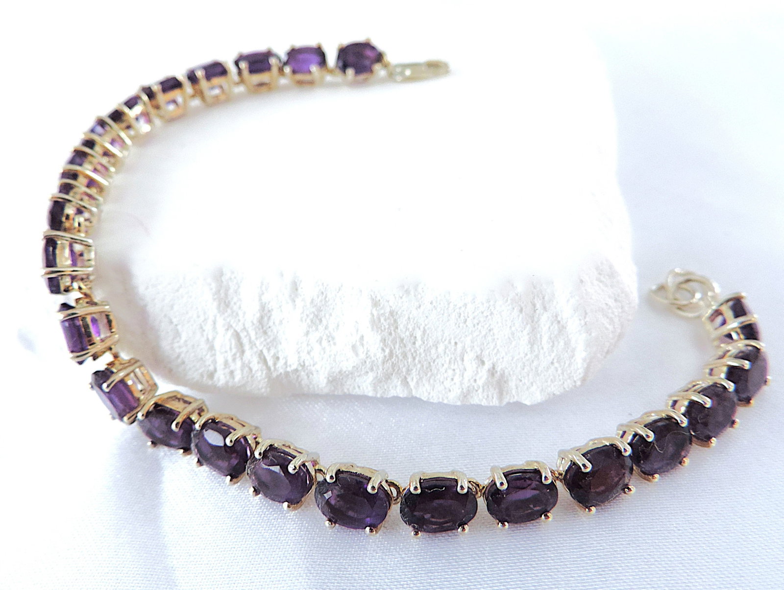 925 Silver 10.35 Carat Amethyst Gemstone Tennis Bracelet: Title: 925 Silver 10.35 Carat Amethyst Gemstone Tennis Bracelet Description: A gorgeous 925 silver tennis bracelet set with 23 x 6x4mm (10.35 TCW) Oval Amethyst gemstones. The bracelet is