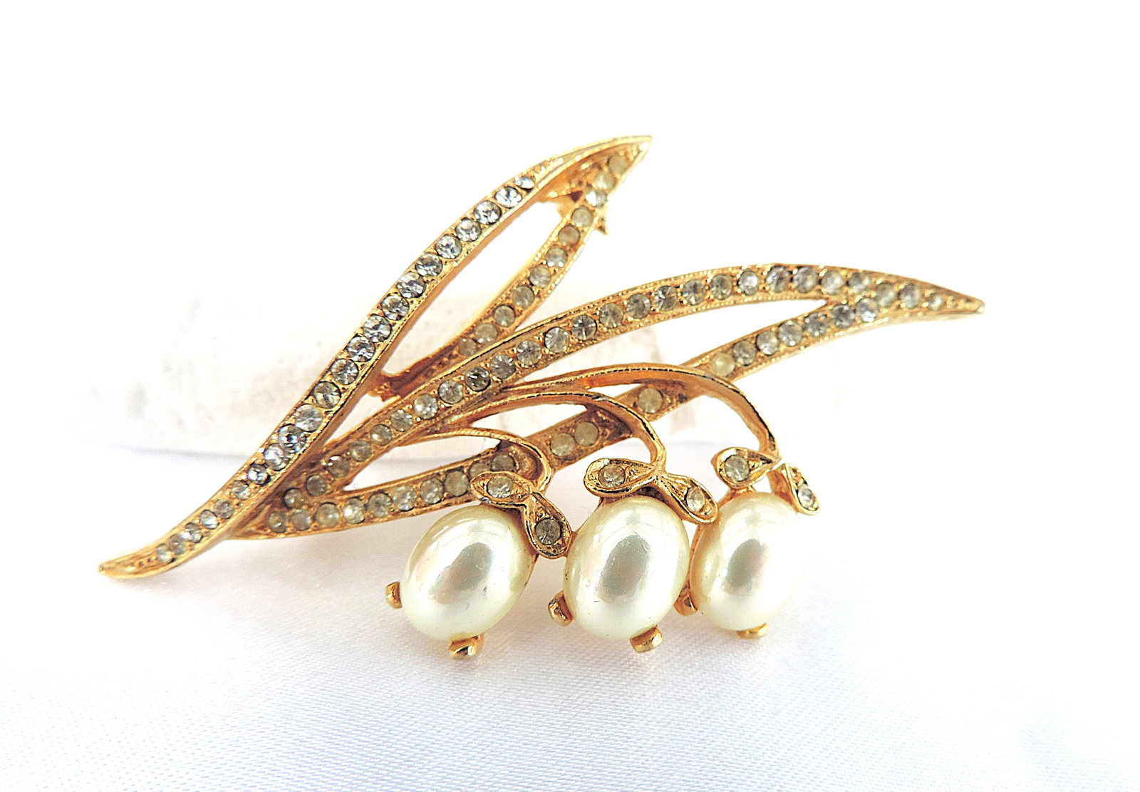 Vintage Crystal & Faux Pearl Brooch: Title: Vintage Crystal & Faux Pearl Brooch Description: A true vintage gold tone metal brooch set with white rhinestone crystals and faux pearls. Brooch is 7cm wide.