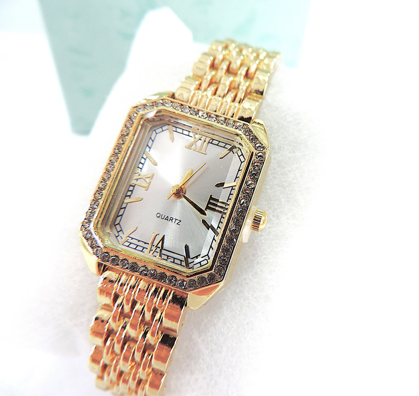 Ladies Quartz Bracelet Watch: Title: Ladies Quartz Bracelet Watch Description: Ladies quartz movement gold tone metal bracelet watch, white face, Roman numerals and white stones surround. New boxed in perfect working order.