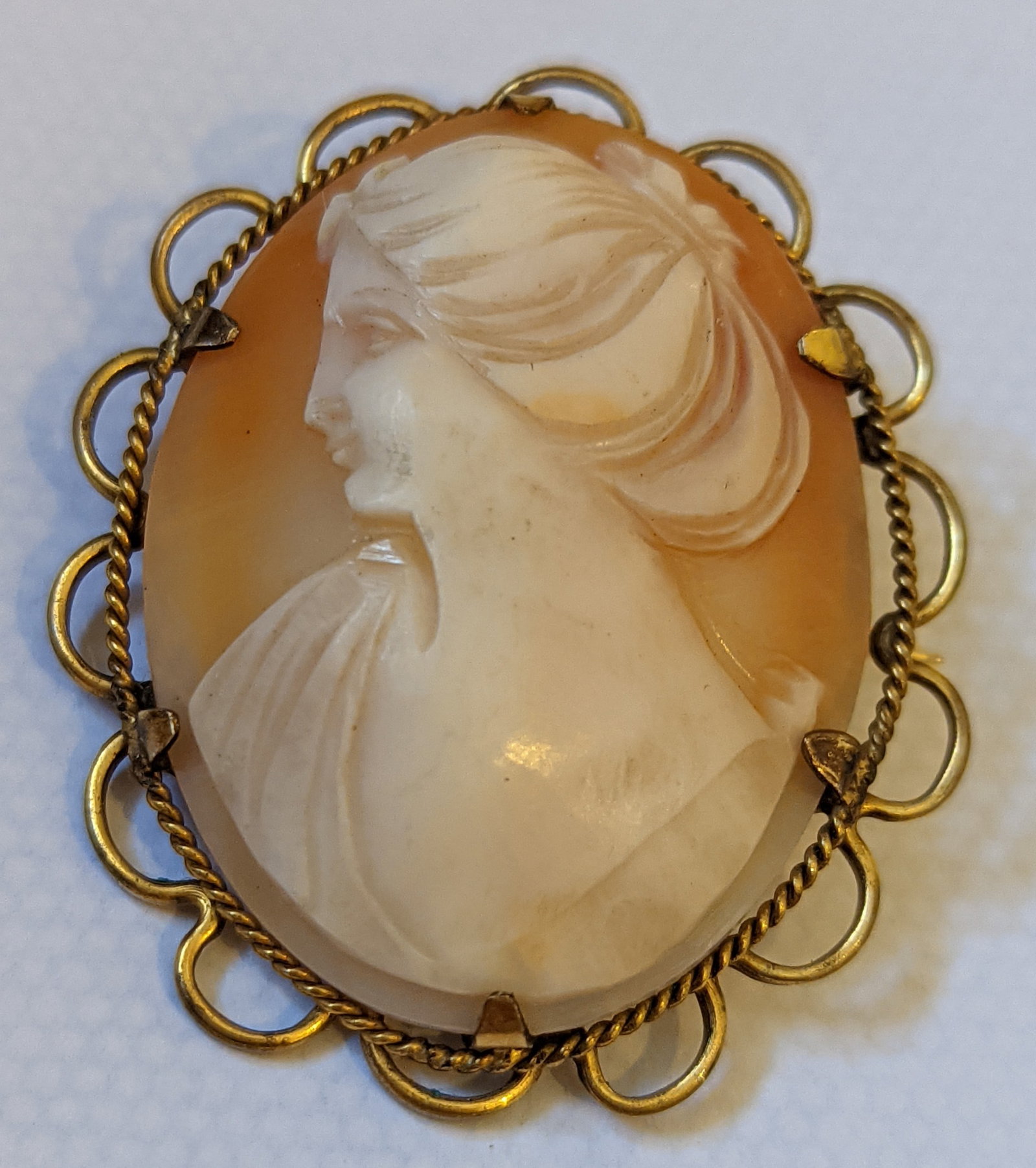 Vintage Rolled Gold Cameo Brooch: Title: Vintage Rolled Gold Cameo Brooch Description: Elegant vintage oval cameo brooch in a rolled gold (gold-filled / scalloped frame with looped edges, twisted-wire trim, and decorative border. The