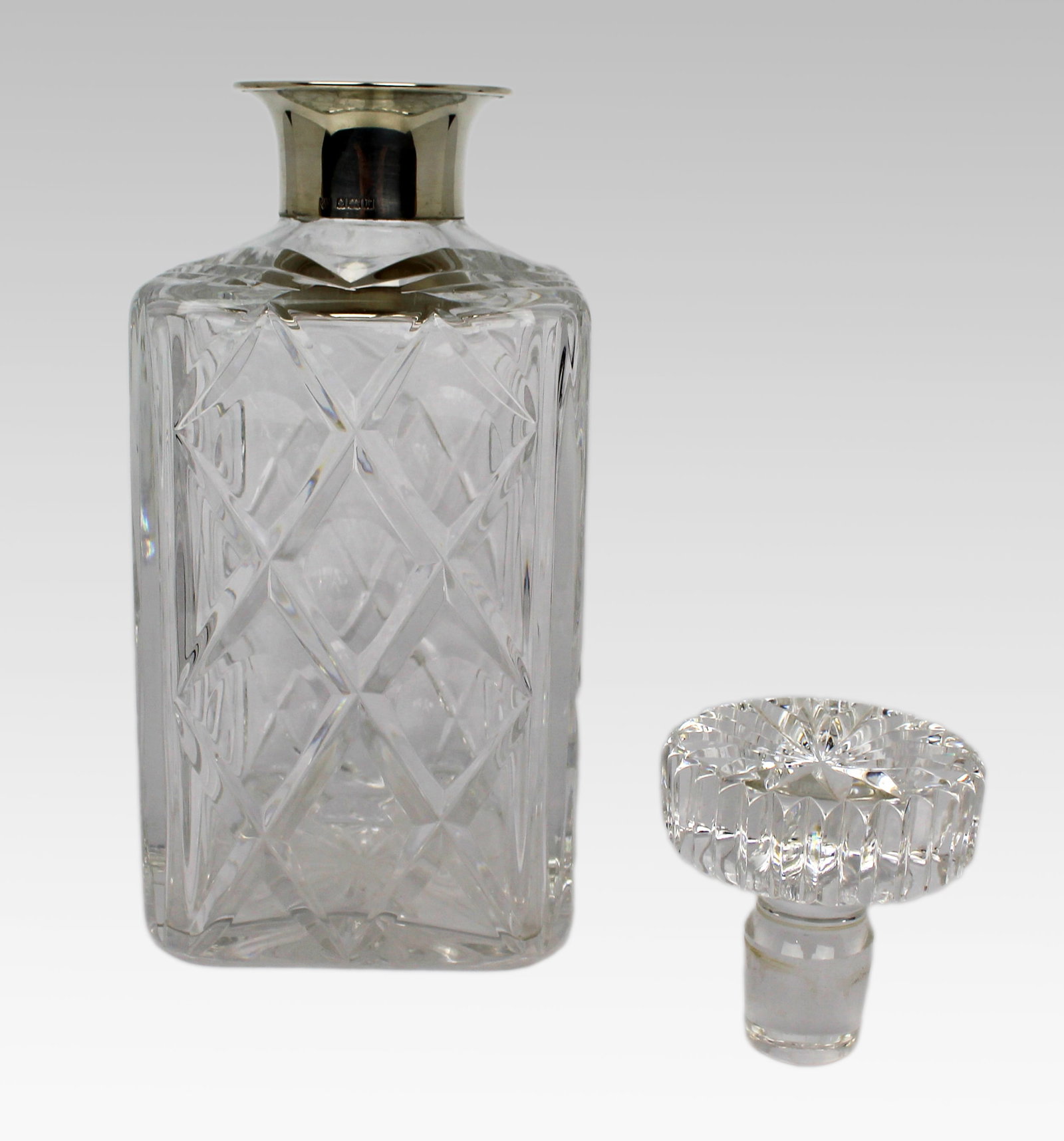 Title: Cut Glass Silver Mounted Decanter Description: Cut Glass Silver Mounted Decanter. Measures 10 - 7
