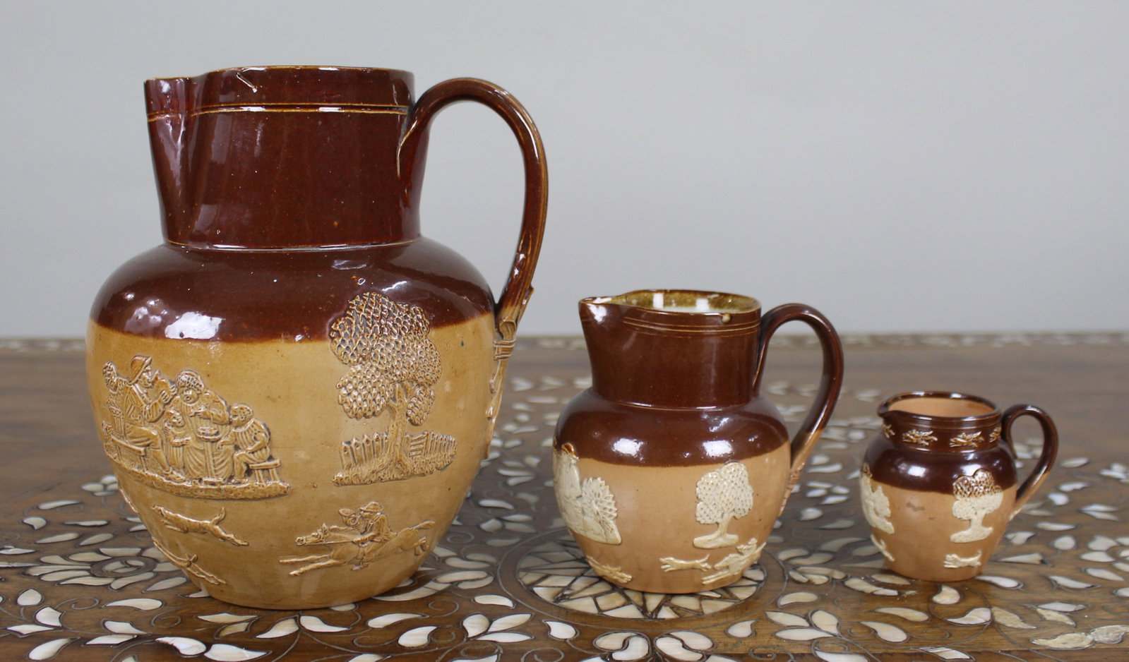 Title: Collection of Three Graduated Doulton Lambeth Stoneware Jugs, c.1900 Description: Set of (1 of 20)
