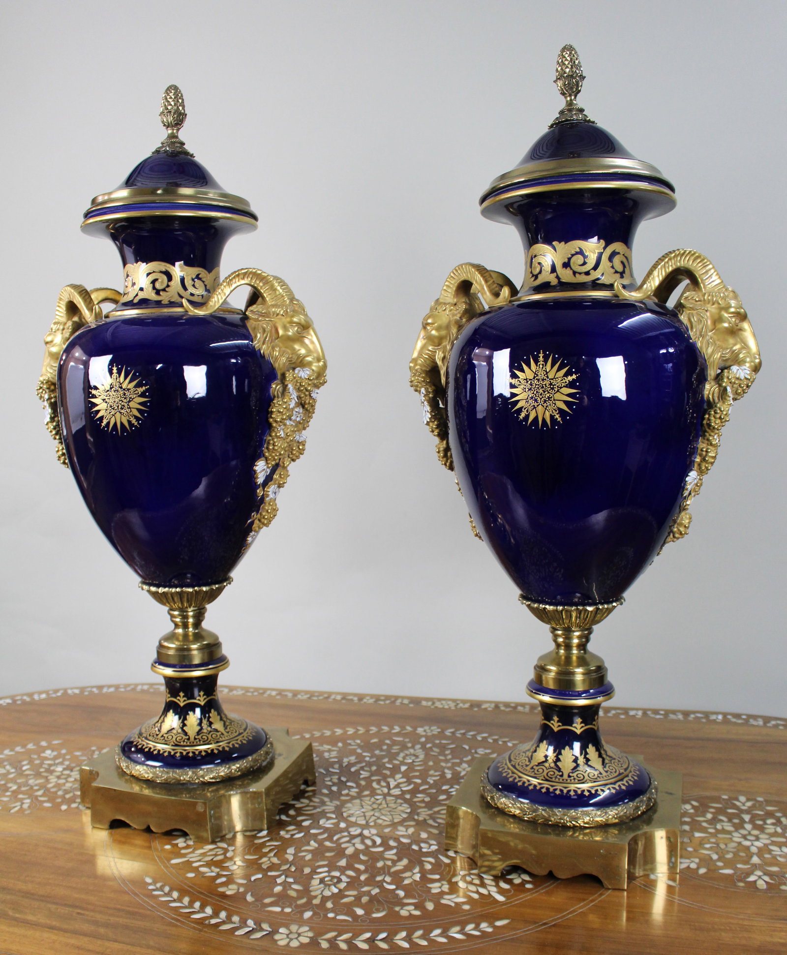 Title: Pair of Fine Sevres Style Cobalt Blue Rams Head Lidded Urns Description: Pair of Fine: Title: Pair of Fine Sevres Style Cobalt Blue Rams Head Lidded Urns Description: Pair of Fine Sèvres Style Cobalt Blue Porcelain and Gilt Brass Ram's Head Lidded Urns We are pleased to offer a fin