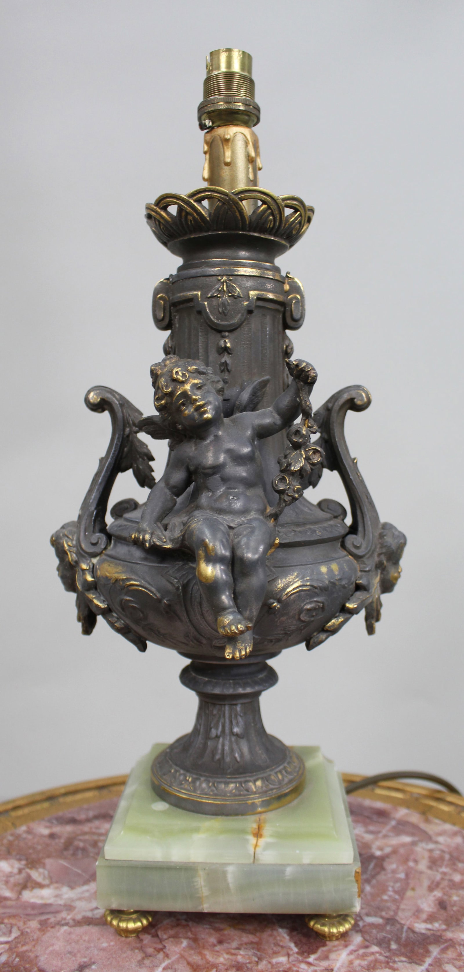 Title: Vintage Gilt Brass Cherub Onyx Table Lamp Description: Vintage Gilt Brass Cherub Table Lamp: Title: Vintage Gilt Brass Cherub Onyx Table Lamp Description: Vintage Gilt Brass Cherub Table Lamp on Onyx Base, modelled as a classical urn with seated cherub, scrolling handles and decorative mask m