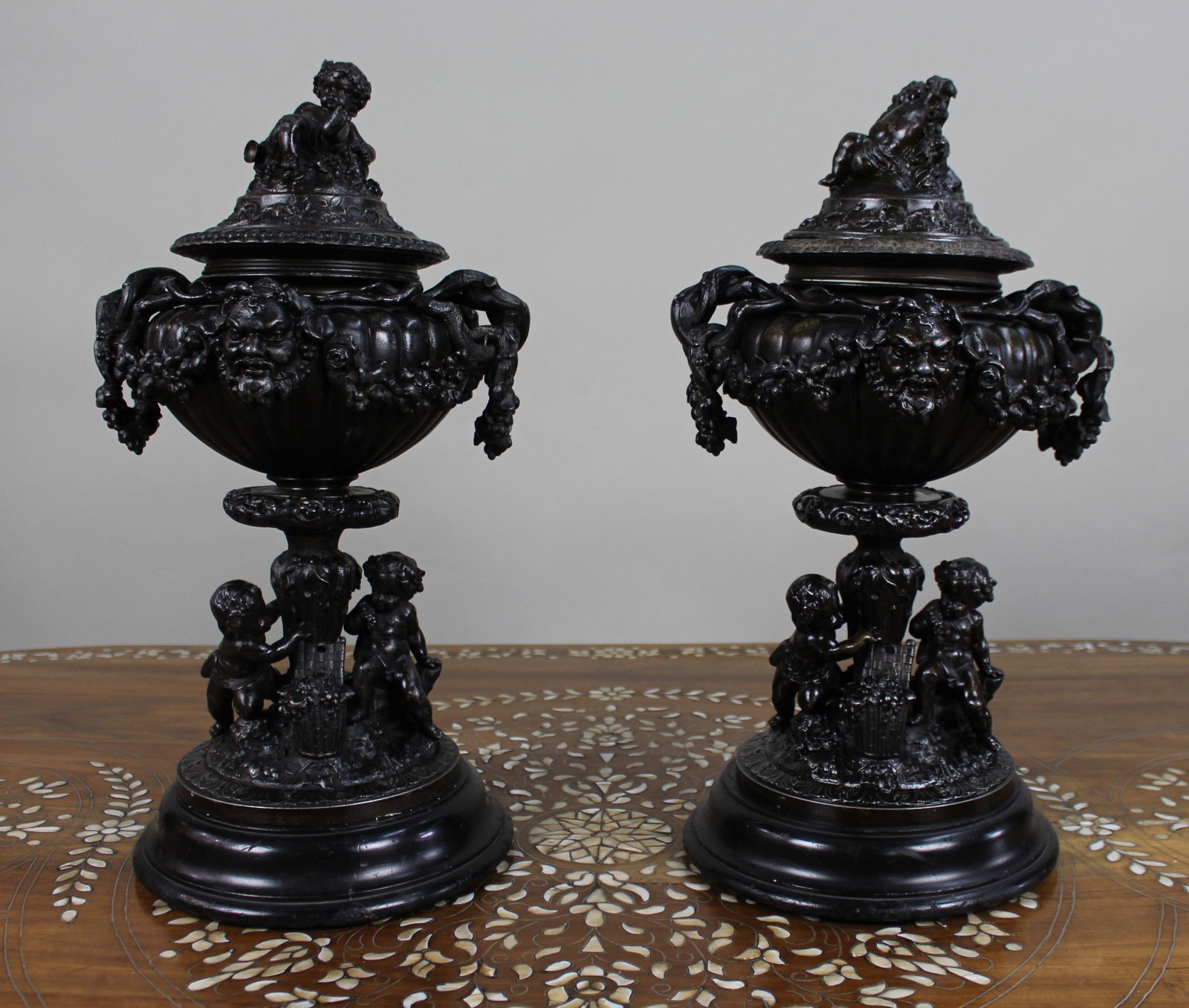 Title: Pair of French Bronzed Spelter Urns with Bacchic Masks and Putti, Circa 1880 Description: (1 of 2)