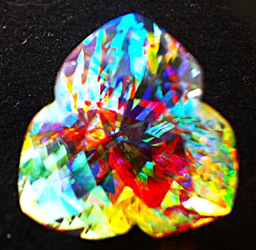 Custom Trillion Cut Mystic Quartz 50 carats: Title: Custom Trillion Cut Mystic Quartz 50 carats Description: A truly mesmerising, Mystic quartz, custom trillion cut. Dimensions: 23.5 x 23.5 x 18.6 mm, weight: 50 carats. One of the
