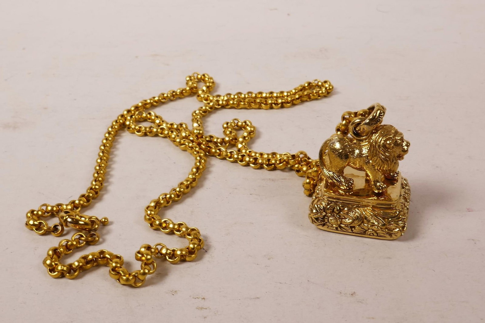 Gold Tone Lion Fob Pendant and Belcher Chain: Title: Gold Tone Lion Fob Pendant and Belcher Chain Description: A decorative gold-tone necklace with a figural lion pendant; the pendant is finely modelled with a seated lion upon an ornate